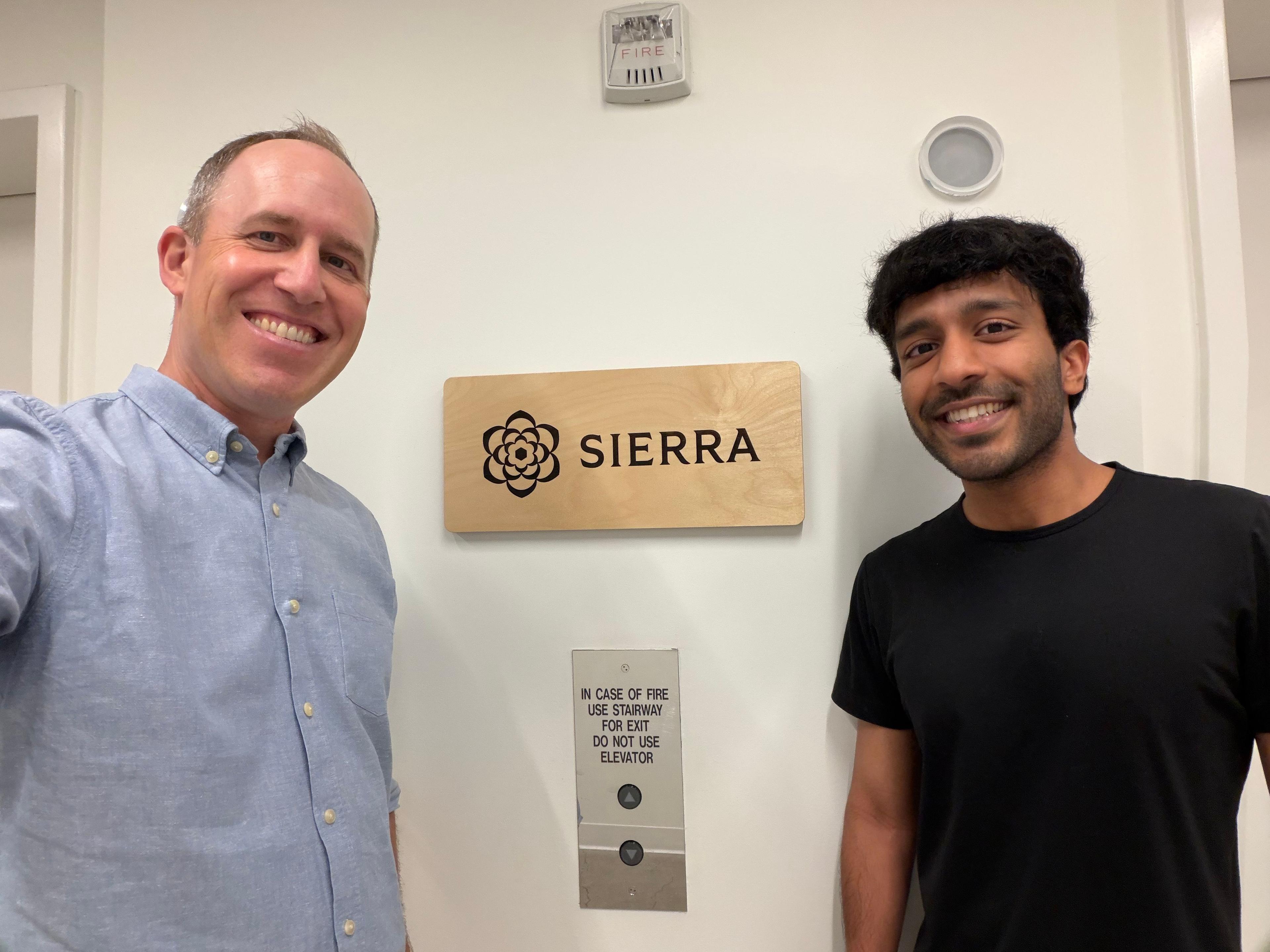 Bret Taylor and Aakash Thumaty post in front of a Sierra sign
