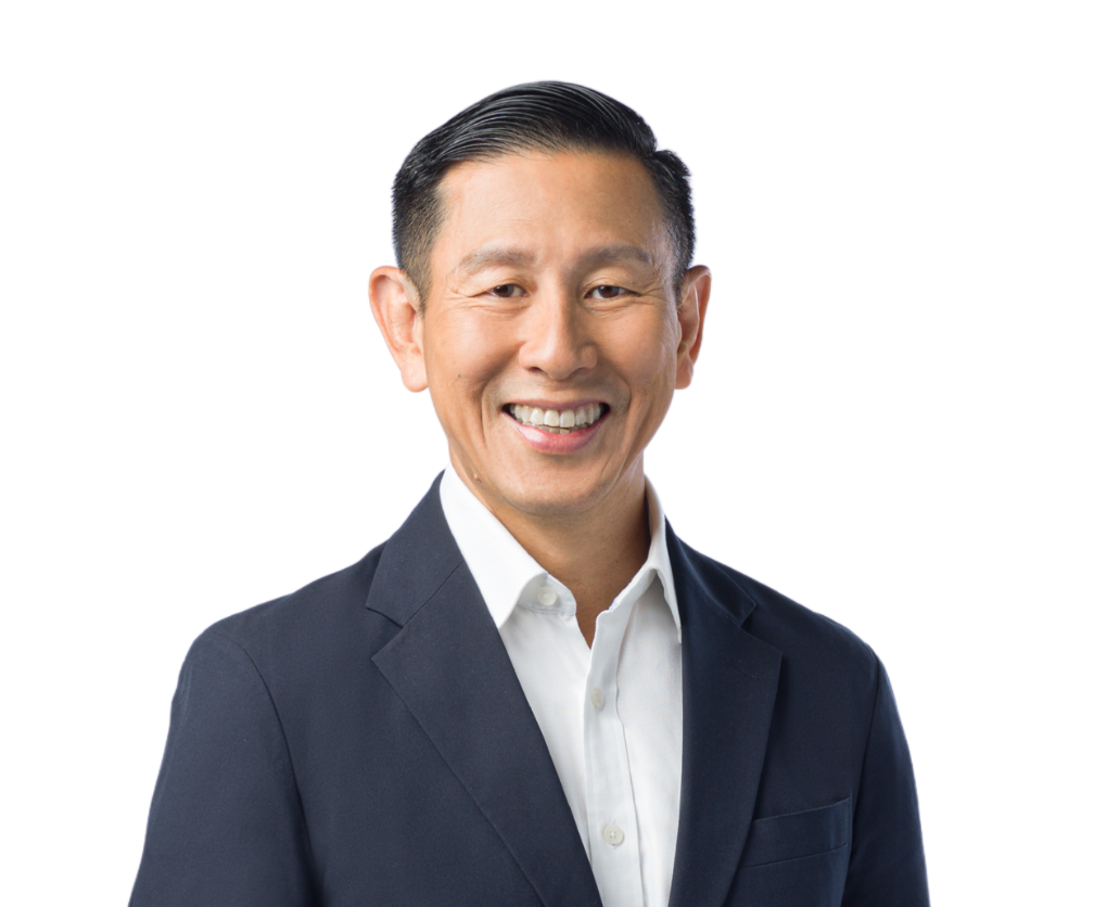 Headshot of an East Asian man in a dark suit jacket and white shirt, smiling against a white background.
